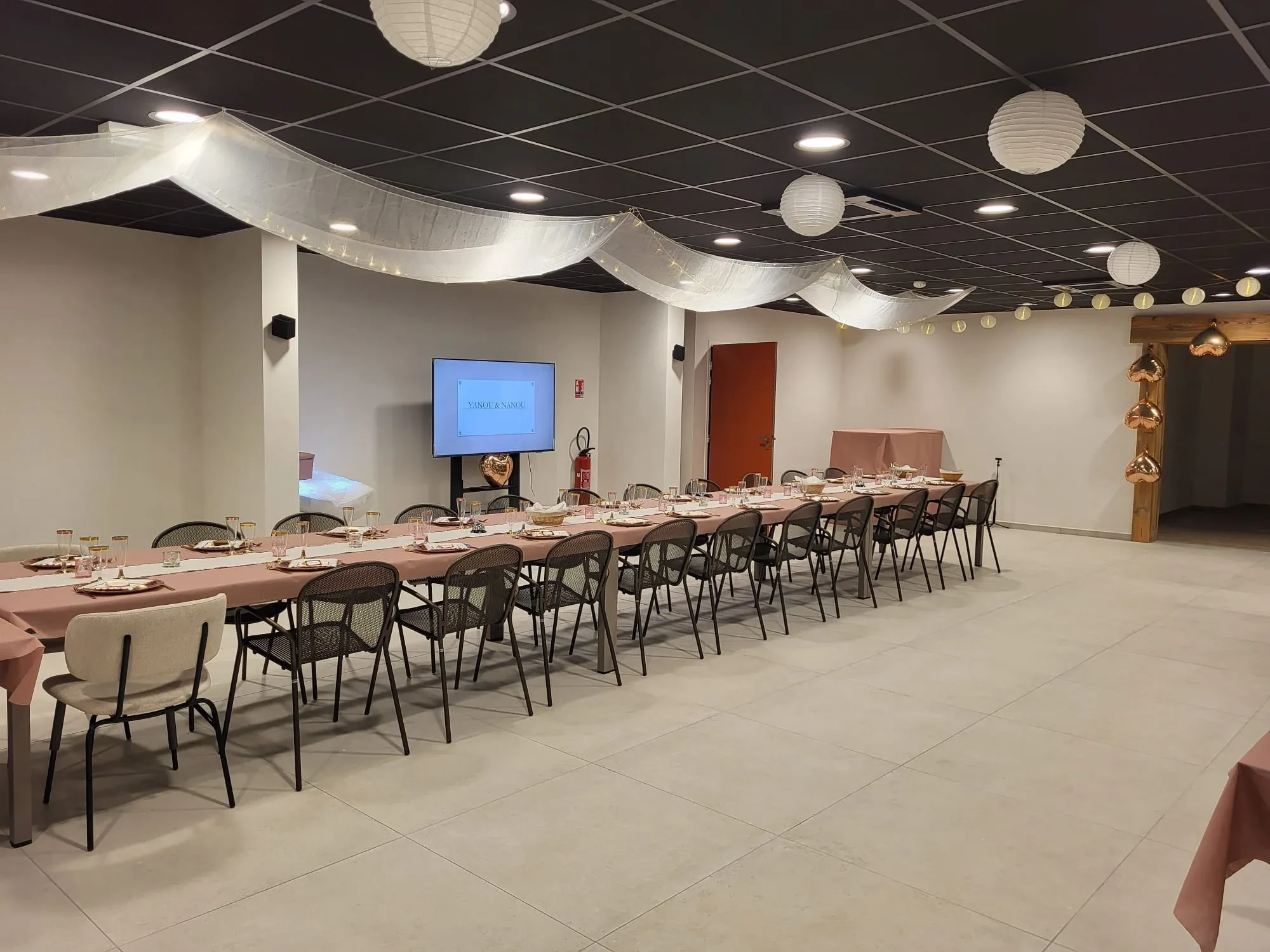 Salle de réception décorée avec tables dressées.