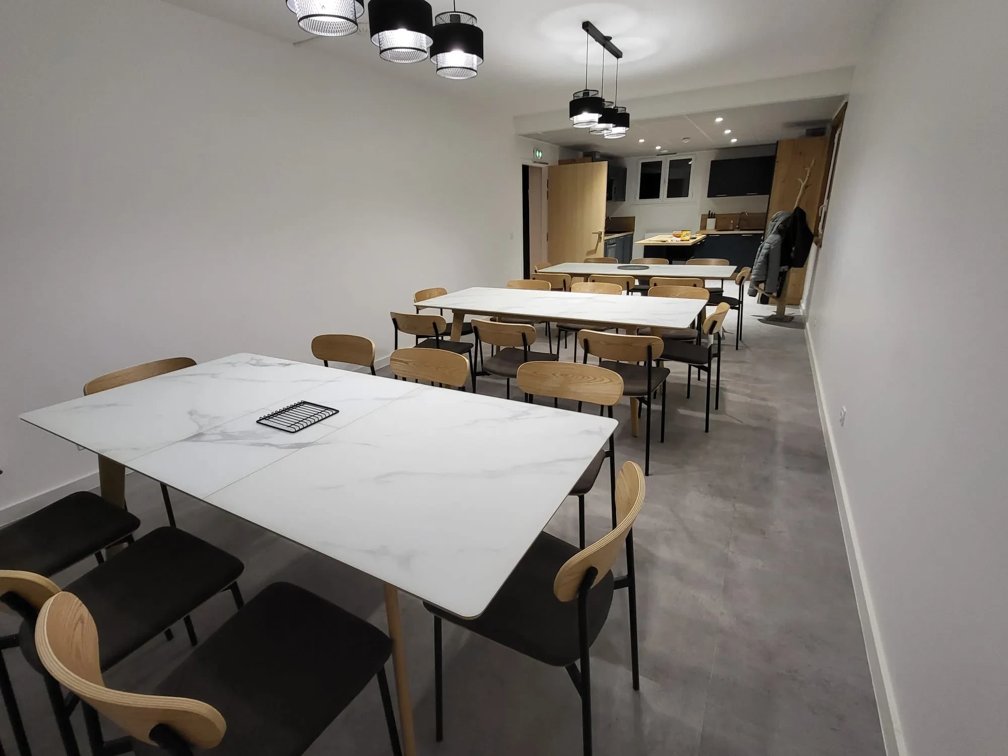 Salle à manger moderne avec chaises et tables blanches.